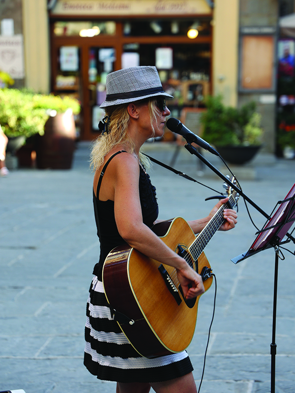 In Cortona's town square, an Italian musician strums the guitar and serenades with song